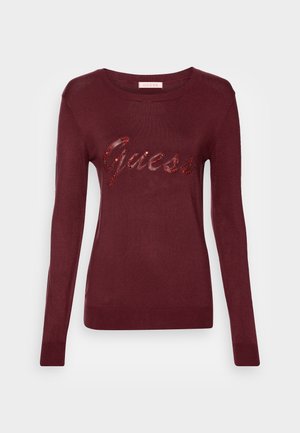 Pull femme bordeaux à manches longues avec encolure ronde et logo "Guess" orné de perles rouges sur la poitrine.
