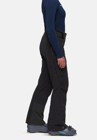 Μαύρο σορτς σκι με στενή σχεδίαση, πλάγια τσέπη με φερμουάρ και υφασμάτινη λεπτομέρεια στο κάτω μέρος. Συνδυασμένο με γκρι μπότες σκι με μπλέ λεπτομέρειες.