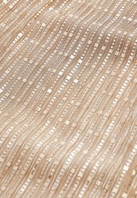 Tissu métallique beige avec des motifs ondulés complexes, présentant des rayures argentées, de petits carrés et des accents circulaires.