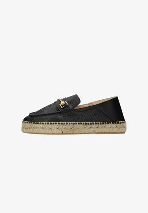 Mocasines tipo alpargata negros con parte superior de cuero texturizado, detalle de herrajes dorados y suela de yute natural, con una forma plana y redondeada.