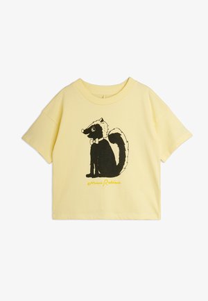 T-shirt jaune à manches courtes avec une mouffette noire et blanche portant un nœud papillon centré sur le devant, avec le texte "Mini Rodini" en dessous.