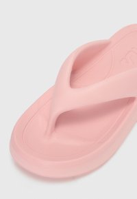 Rosa plastikklepp med en V-formet stropp, teksturert såle og en glatt yttersåle, designet for uformell bruk.