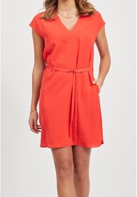 Czerwona sukienka do kolan z dekoltem w kształcie litery V i rękawkami typu cap. Posiada pasek w talii oraz boczne kieszenie. Gładka faktura, prosty design.