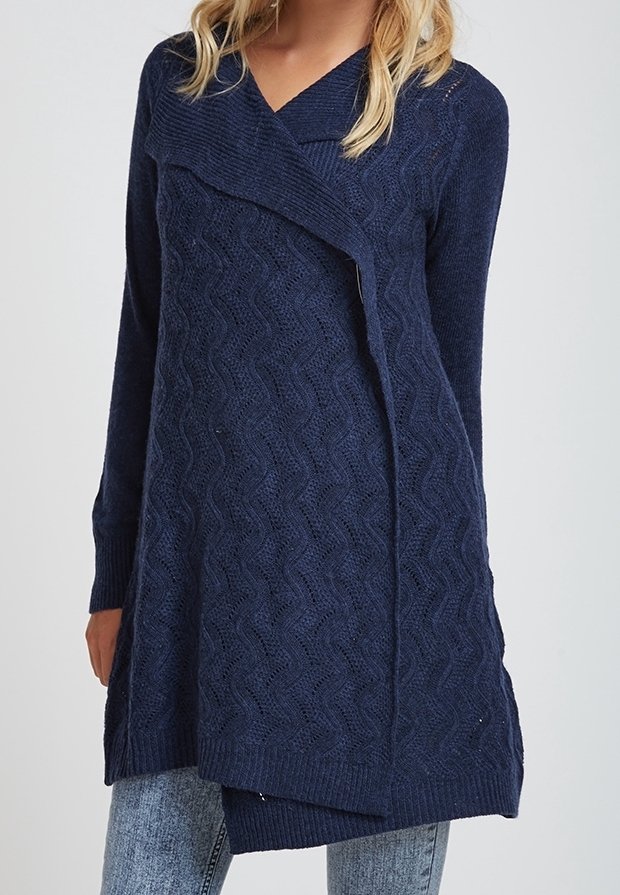 Navy blue knitted tunic with a wave pattern, V-neck, and asymmetrical hem. Long sleeves with ribbed cuffs and textured fabric.