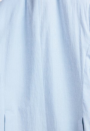 Lichtblauw shirt met verticale witte strepen, met een gestructureerde stof en een subtiele glans. Inclusief zijslits voor extra comfort.