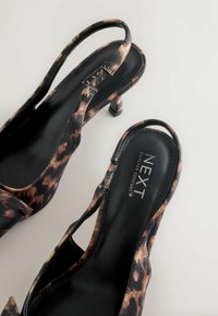 Lodičky s leopardím vzorem, se zádovým designem a hladkým černým podšívkou, na stiletto podpatku. Disponují výřezovým designem a značenou stélkou.