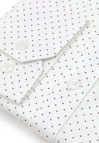 Biała koszula z małymi brązowymi kropkami, posiadająca złożony kołnierzyk i dwa zapięcia na guziki. Tkanina wydaje się gładka o wyraźnej teksturze.