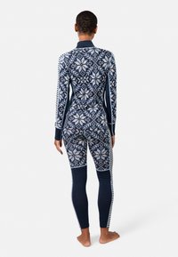 Langärmliger thermischer Ganzkörperanzug in Marineblau und Weiß. Verfügt über ein Schneeflockenmuster, eine glatte Textur und ein eng anliegendes Design mit kontrastierenden Streifen.