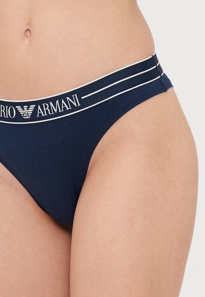Navyblauwe katoenen string met een merk-elastische tailleband, voorzien van witte letters en twee dunne witte strepen langs de bovenkant.