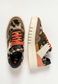 Zapatillas multicolores con un upper texturizado similar al pelo, acentos de cuero suave, cordones naranjas y una gruesa suela blanca.