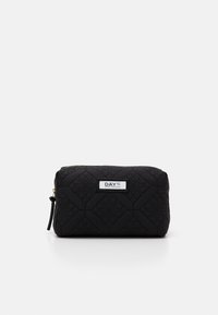 Neceser de cosméticos negro acolchado con un patrón texturizado, cierre de cremallera y etiqueta de la marca. Forma rectangular compacta con una correa de muñeca.