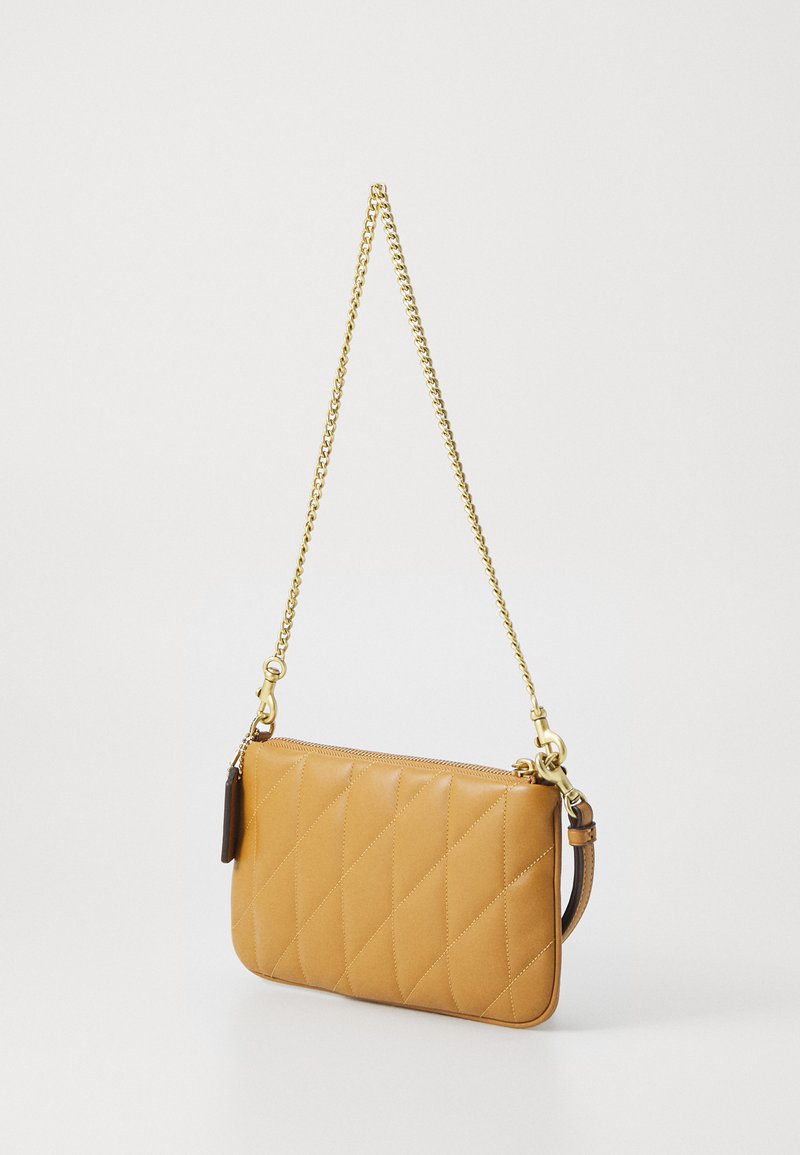 Gequilte tan leren clutch tas met een gouden kettingriem, voorzien van een ritssluiting en een klein leren label detail.