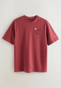 Bordo aluepaita, jossa on grafiikka surffaajasta ja keltaisesta auringosta. Lyhyet hihat ja pyöreä pääntie rentoa istuvuutta varten.