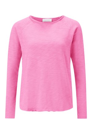 Langemouwshirt in lichtroze, gemaakt van een zachte, gestructureerde stof. Heeft een ronde halslijn en raglanmouwen. Platte naaddetails aanwezig.