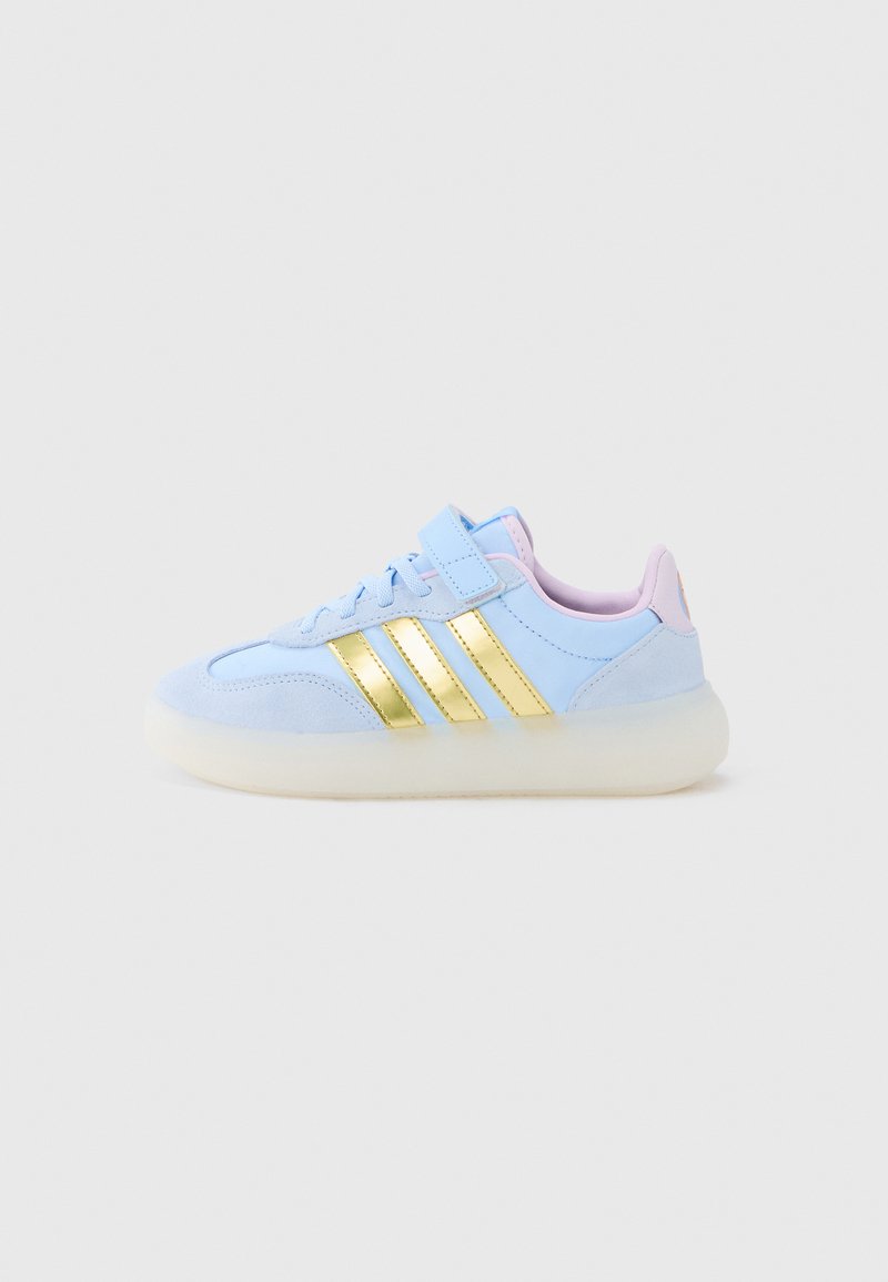 Vaaleansiniset mokkanahkaiset lenkkitossut, joissa on kultaiset raidat, vaaleanpunainen pehmustettu kaulus ja paksu läpikuultava pohja. Tarrakiinnitys.