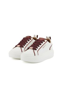 Sneaker bianco con lacci e dettagli bordeaux, materiale sintetico liscio, punta rotonda, suola spessa bianca e un cordino decorativo.