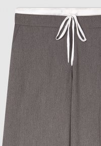 Szare spodnie o gładkiej fakturze, z białym sznurkiem w talii oraz subtelnymi pionowymi paskami dla dodatkowego efektu.