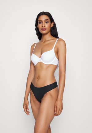 White padded bra with adjustable straps paired with black high-waisted bikini bottoms. Smooth fabric, minimalist design, no visible patterns.