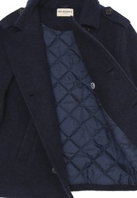 Cappotto in misto lana blu navy con una fodera trapuntata blu, caratterizzato da un design doppiopetto e bottoni neri. Include tasche laterali.