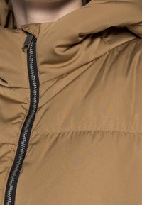 Giacca a vento marrone con zip e cappuccio. Finitura liscia e opaca con dettagli arricciati. La zip nera a contrasto valorizza il design.