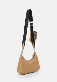 Borsa a spalla in nylon marrone con forma curvata, cinturino regolabile nero a contrasto, accessori in argento e una piccola tasca laterale con zip.