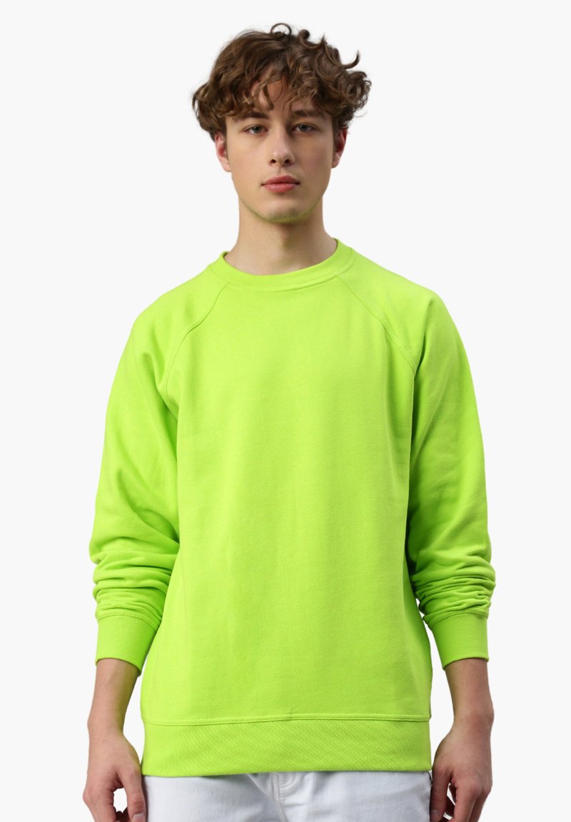 Felpa verde neon in un tessuto morbido, con colletto a girocollo e maniche raglan. I polsini e l'orlo sono a coste per una maggiore texture.