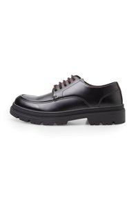 Scarpe nere in pelle con lacci, punta rotonda, suola spessa in gomma e lacci bordeaux, presentano una superficie liscia e un design minimal.