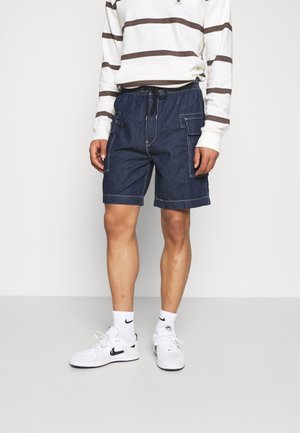 Dunkelblaue Denim-Cargoshorts mit weißer Kontrastnaht, ausgestattet mit mehreren Seitentaschen und einem elastischen Bund mit Kordelzug.