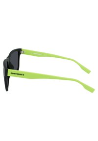 Czarne okulary przeciwsłoneczne z zielonymi plastikowymi ramionami. Oprawki są prostokątne, z matowym wykończeniem, i mają logo "CONVERSE" po bokach.