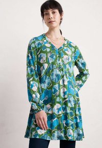 Túnica floral en verde, azul y blanco, con mangas largas, escote en V y detalle fruncido. Fabricada con un tejido suave y de corte holgado.