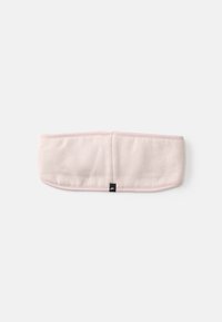 Faixa de cabelo de tecido rosa claro com uma textura suave, forma arredondada e uma etiqueta preta de marca em um dos lados.