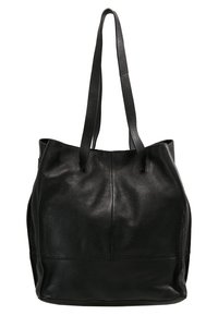 Sac cabas en cuir noir avec doubles anses d'épaule et une surface légèrement texturée, posé debout sur un fond blanc.