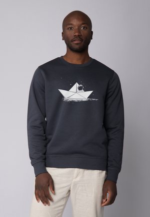 Navy blue sweatshirt made of cotton blend, featuring a white graphic of a paper boat and astronaut on water, crew neckline, ribbed cuffs.