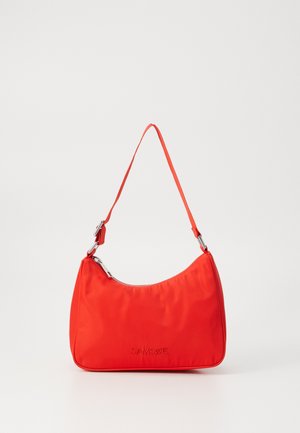 Sac à main en nylon rouge avec une silhouette courbée, une seule anse, des accessoires en métal argenté et un logo embossé à l'avant. Texture lisse.