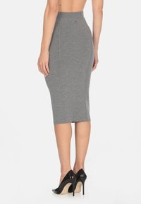 Gonna a matita grigia in tessuto knit lisci, con vita alta e dettagli delle cuciture, abbinata a scarpe con tacco alto nere.