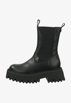Black ankle boots with leather upper and elastic side panels. Thick, textured rubber sole with deep tread pattern for traction. Boot pulls at the back.