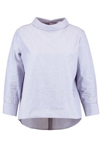 Blouse bleu clair à manches longues avec un col rond haut et un ourlet légèrement courbé, présentée sur fond blanc.
