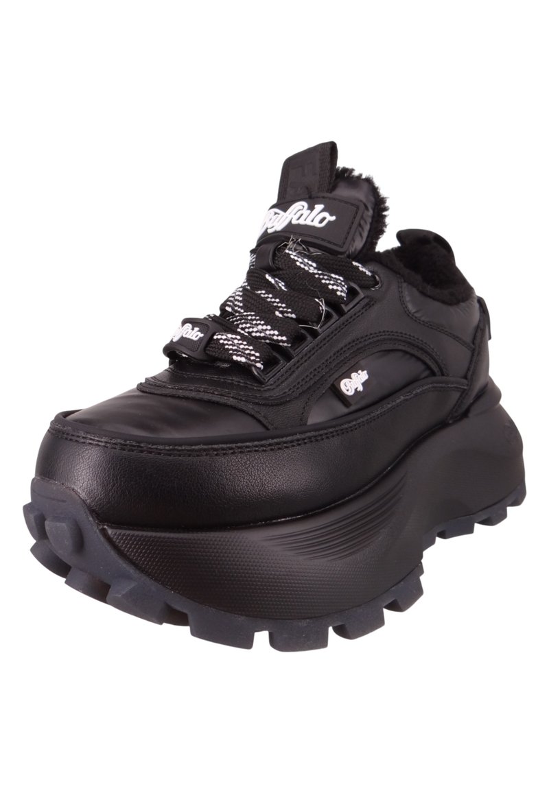 Zapatilla negra con suela gruesa, parte superior de cuero, detalles texturizados y cordones de patrón en blanco y negro. Cuenta con un collar acolchado y un detalle de logo.