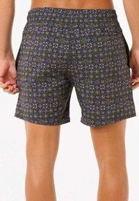 Shorts avec un fond noir présentant un motif géométrique en violet, jaune et vert, finis avec une taille élastique et des poches latérales.