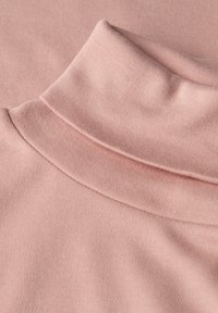 Helles pinkes Rollkragenoberteil, gerippte Textur, weicher Stoff, mit umgeschlagenem Kragen und glatter Oberfläche. Keine sichtbaren Muster oder Beschläge.
