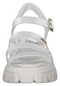 Valkoiset hihnatossut paksulla pohjalla, valmistettu sileästä synteettisestä materiaalista. Varustettu säädettävällä soljella ja hienovaraisilla kultaisilla yksityiskohdilla.