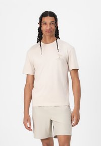 Beige cotton T-shirt with short sleeves and a round neckline, featuring a small palm tree graphic and brand logo on the left chest.