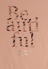 Tela de color rosa con un gran texto estampado que dice "Hermoso" y un texto más pequeño en plata "Momentos Amistosos", acentuada por tachuelas.