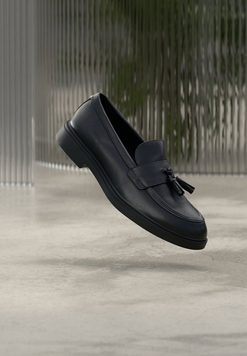 Svarta loafers i läder med slät yta, rundad tå och dekorativa tofsar framtill. Flexibel gummisula med låg klack.