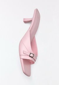 Mule en cuir rose à talon avec bout carré, bride croisée et petite boucle argentée sur fond blanc.