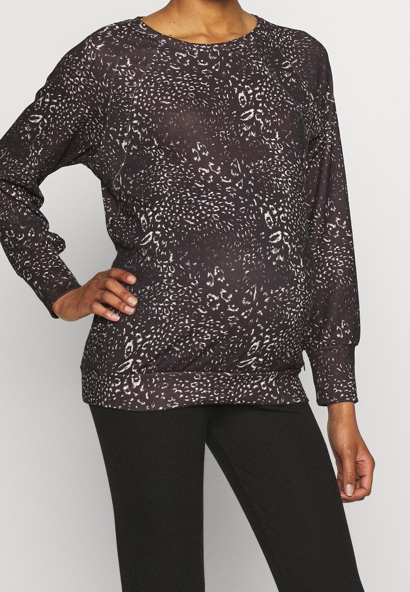 Materniteitspullover in donkerbruin met een wit dierenprintpatroon, lange mouwen, ronde halslijn en een geribbelde boord voor een goede pasvorm.