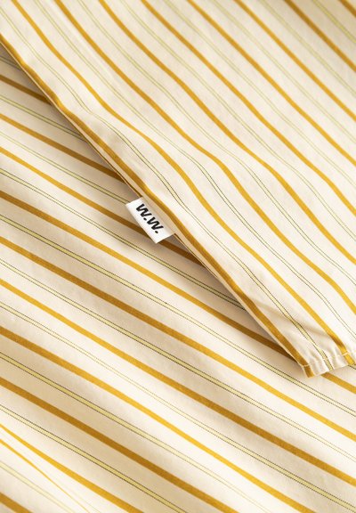 Raidallinen puuvillakangas, jossa on kermanvärinen pohja ja keltaisia sekä harmaita viivoja, kulmassa pieni "W.W."-merkki. Pehmeä koostumus ja kevyt materiaali.