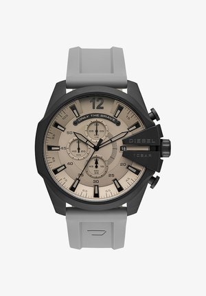 Orologio cronografo da polso con quadrante beige, indici neri, tre subquadranti, finestra della data, cassa nera e cinturino in silicone grigio.