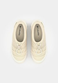 Beige quiltede slip-on sko med en hvid gummisål, som har en toggle lissejustering og indvendig foring for ekstra komfort.