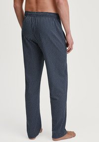 Pantaloni per pigiama blu navy con un motivo geometrico bianco, vita elastica e taglio dritto, realizzati in un tessuto leggero e traspirante.